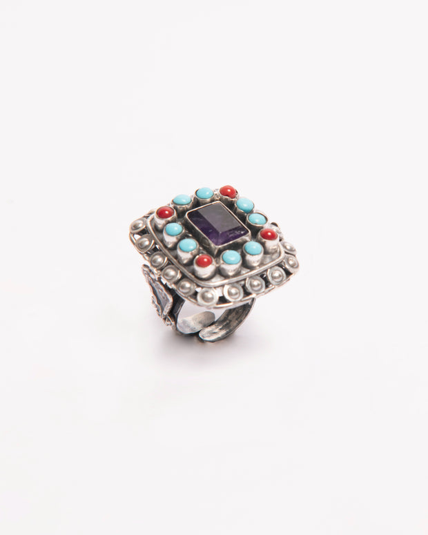 Anillo plateado con piedras turquesa y acentos rojos, piedra central rectangular