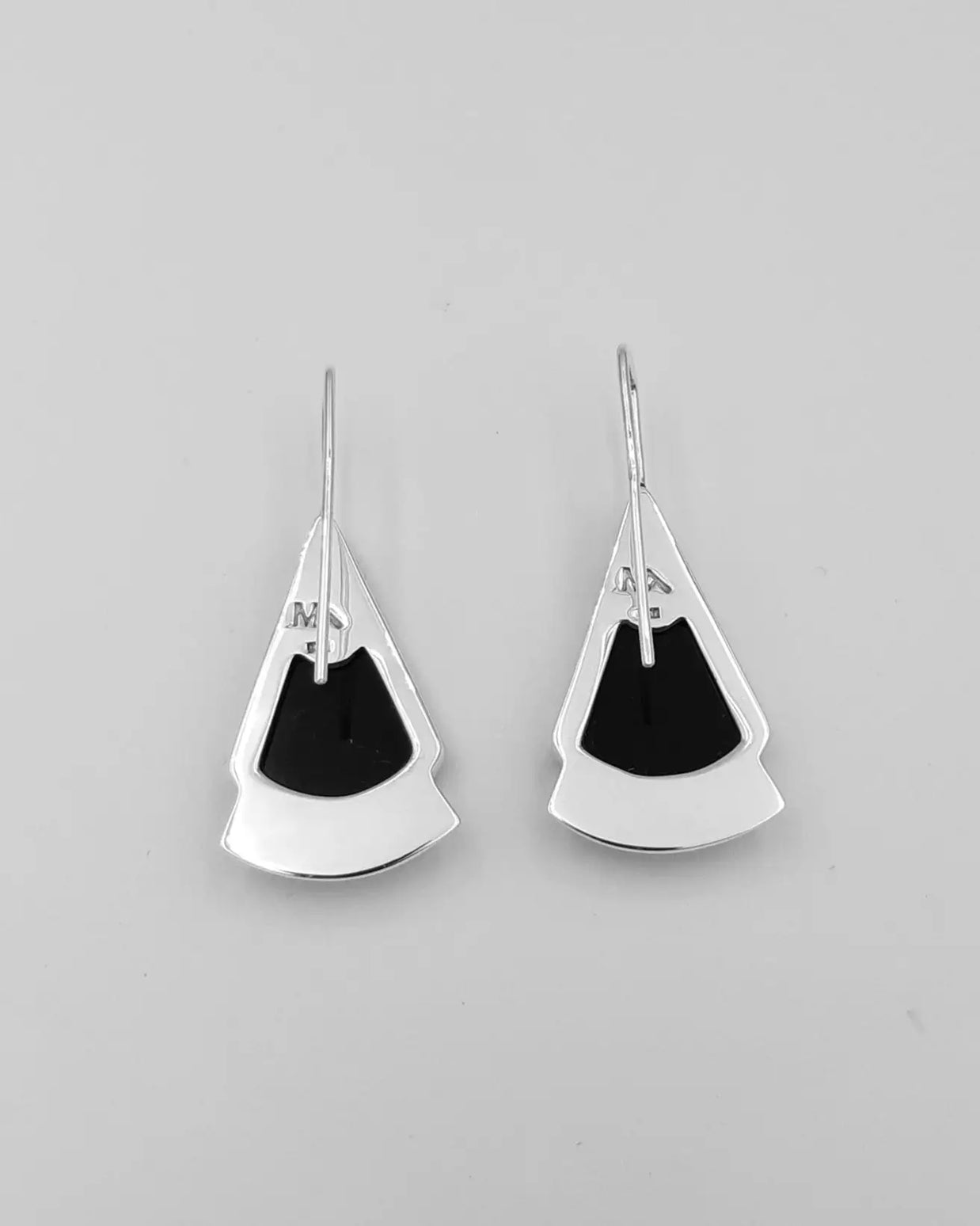 Pendientes colgantes plateados con pieza negra triangular y cierre tipo gancho