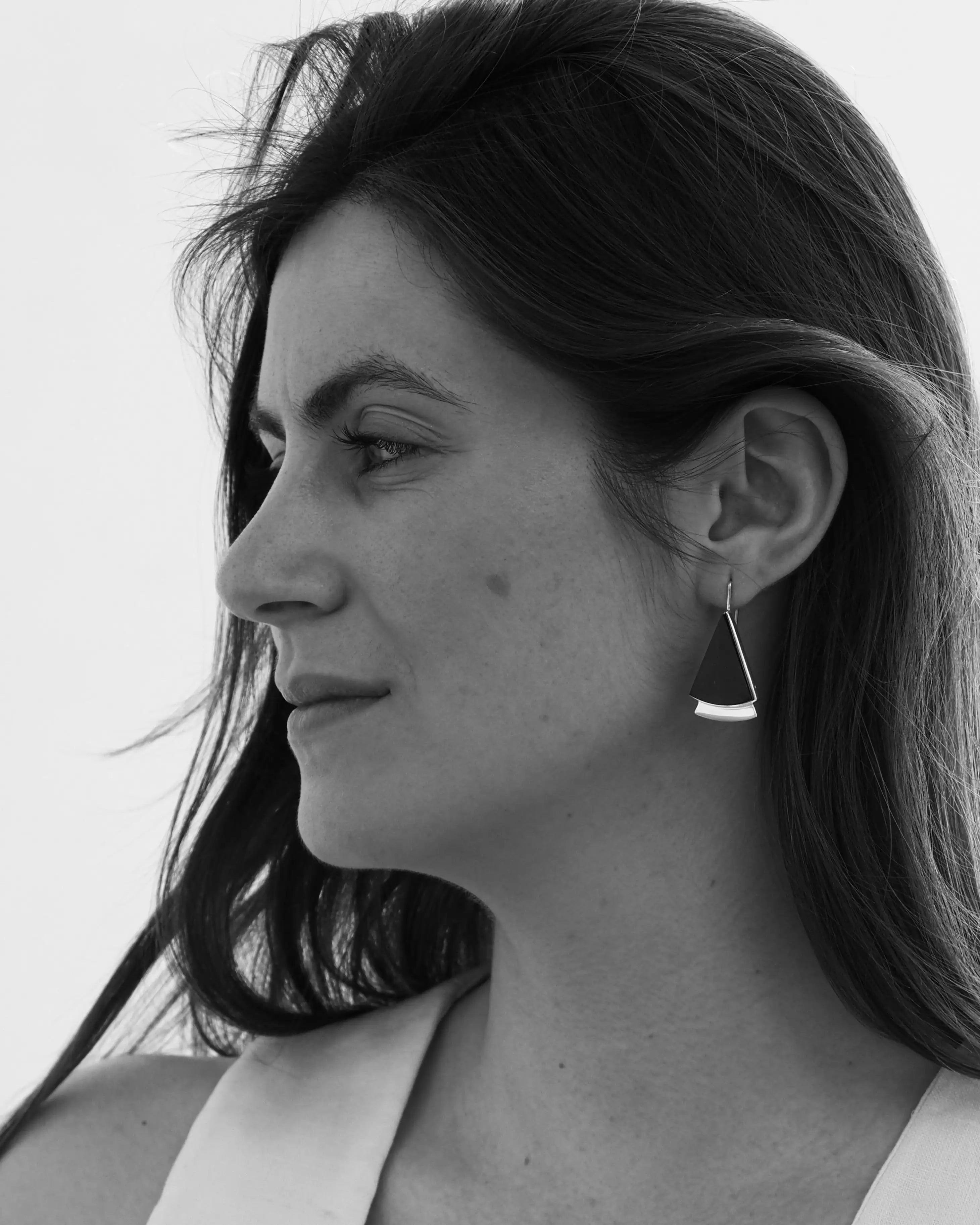Pendientes colgantes con pieza negra y aro plateado, en la oreja