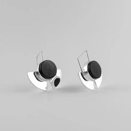 Pendientes con disco negro y base plateada tipo soporte, vista frontal