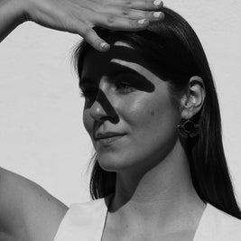 Pendientes de disco negro con aro plateado, llevados por una modelo