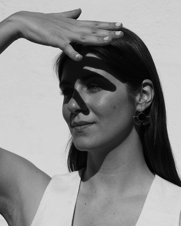 Pendientes de disco negro con aro plateado, llevados por una modelo