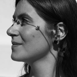 Pendientes elípticos negros con montura plateada, oreja de perfil
