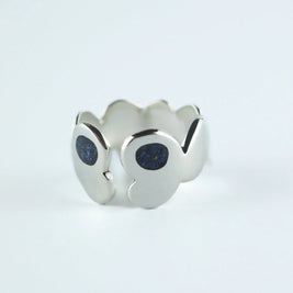 Anillo plateado con piedras azules tipo glitter en el frente