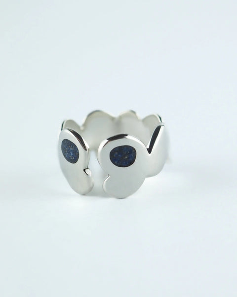Anillo plateado con piedras azules tipo glitter en el frente