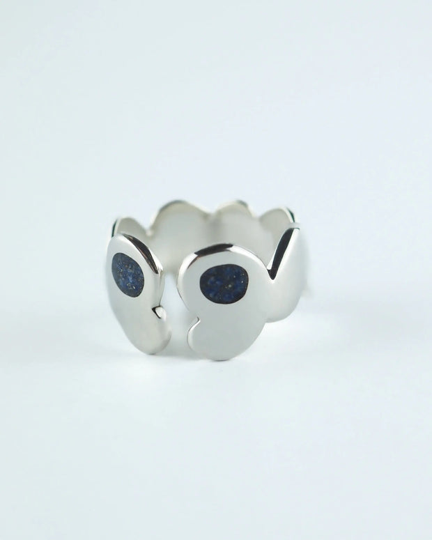 Anillo plateado con piedras azules tipo glitter en el frente