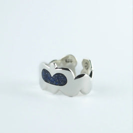 Anillo plateado con dos piedras ovaladas azules y detalle en el lateral
